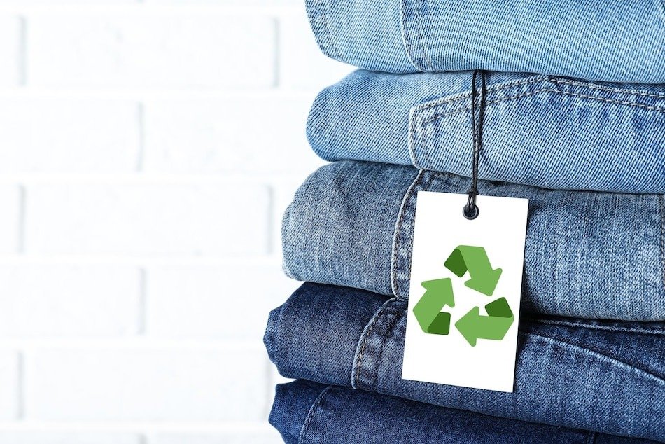 Folded recycled denim with a recycling symbol